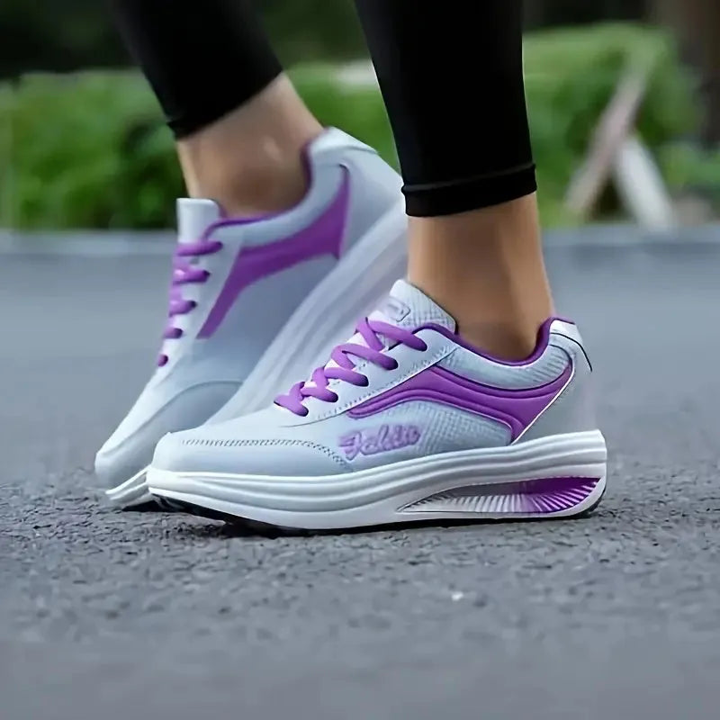 Women's grey and pink sports shoes with a middle heel on a plain background
