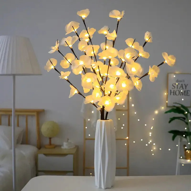 Pink LED orchid branch decorative light on a bedside table.