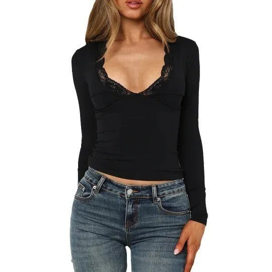 Women's slim-fit long sleeve black top with lace flower detail on front.