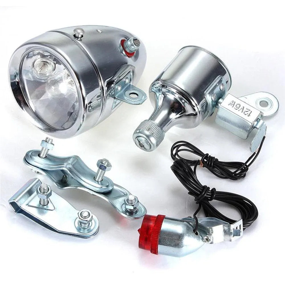 Silver bicycle dynamo generator light kit mounted on a bike frame for friction-powered 12V headlight and tail light