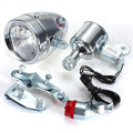 Silver bicycle dynamo generator light kit mounted on a bike frame for friction-powered 12V headlight and tail light