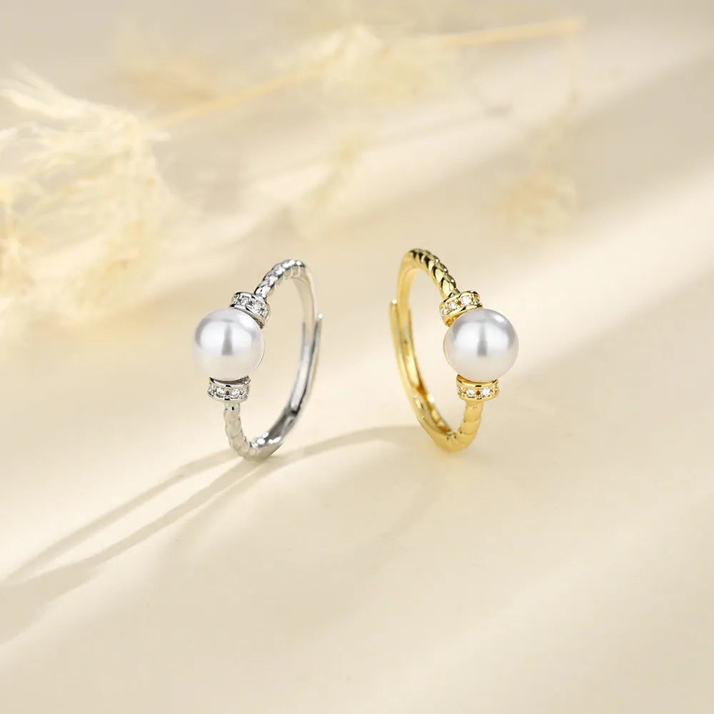 Geometric antique twist ring with a central pearl, on an adjustable copper band in gold colour.