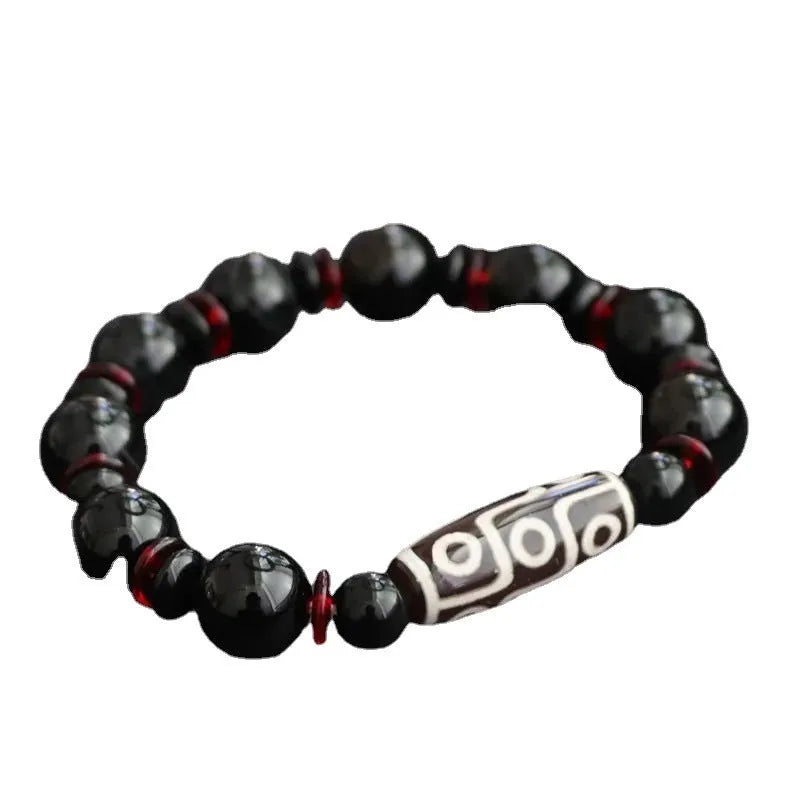 Hand-woven black agate dzi bead bracelet with 11mm geometry beads on a wrist.