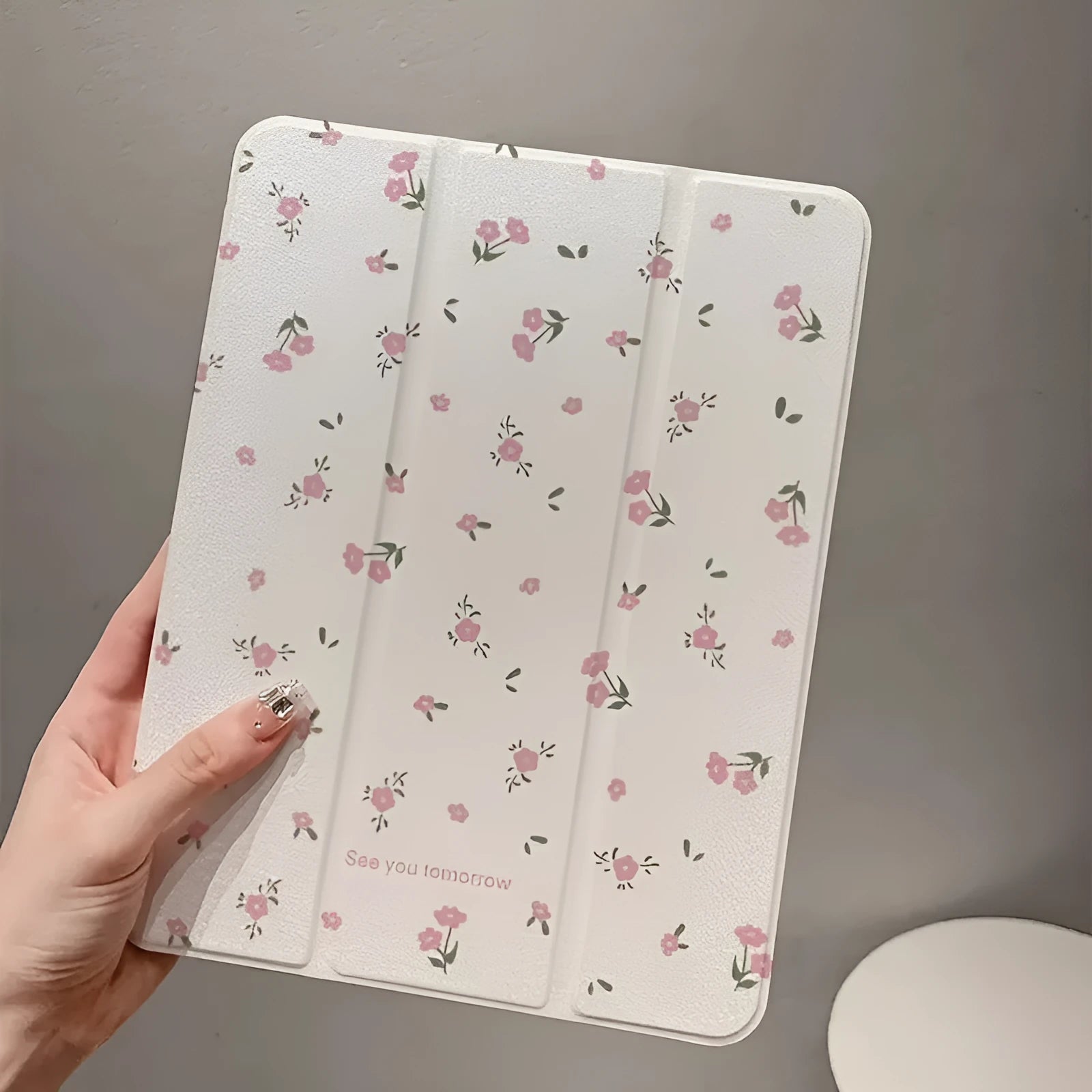 Transparent floral tri-fold iPad case showing magnetic stand function and clear polycarbonate construction