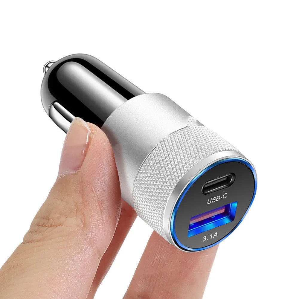 Aluminium alloy twin USB car charger shown in black, plugged into a car dashboard 12V socket.