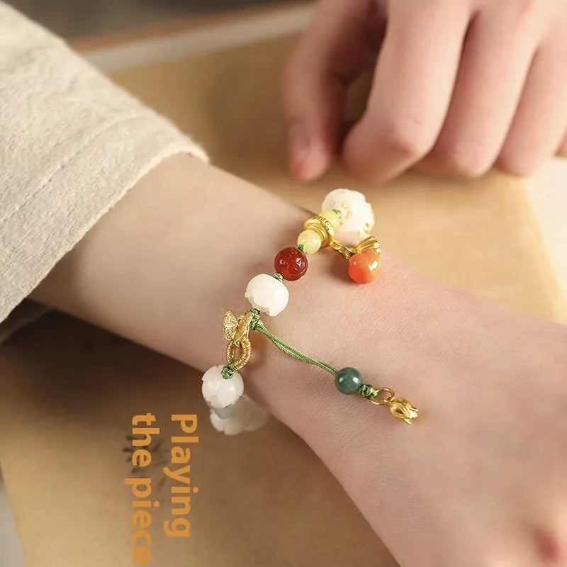 Hand-woven white jade bodhi bracelet showing pumpkin and lotus beads on adjustable open rope