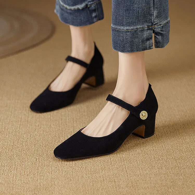 Women's black suede Mary Jane pumps with a chunky block heel and square toe on a plain background.