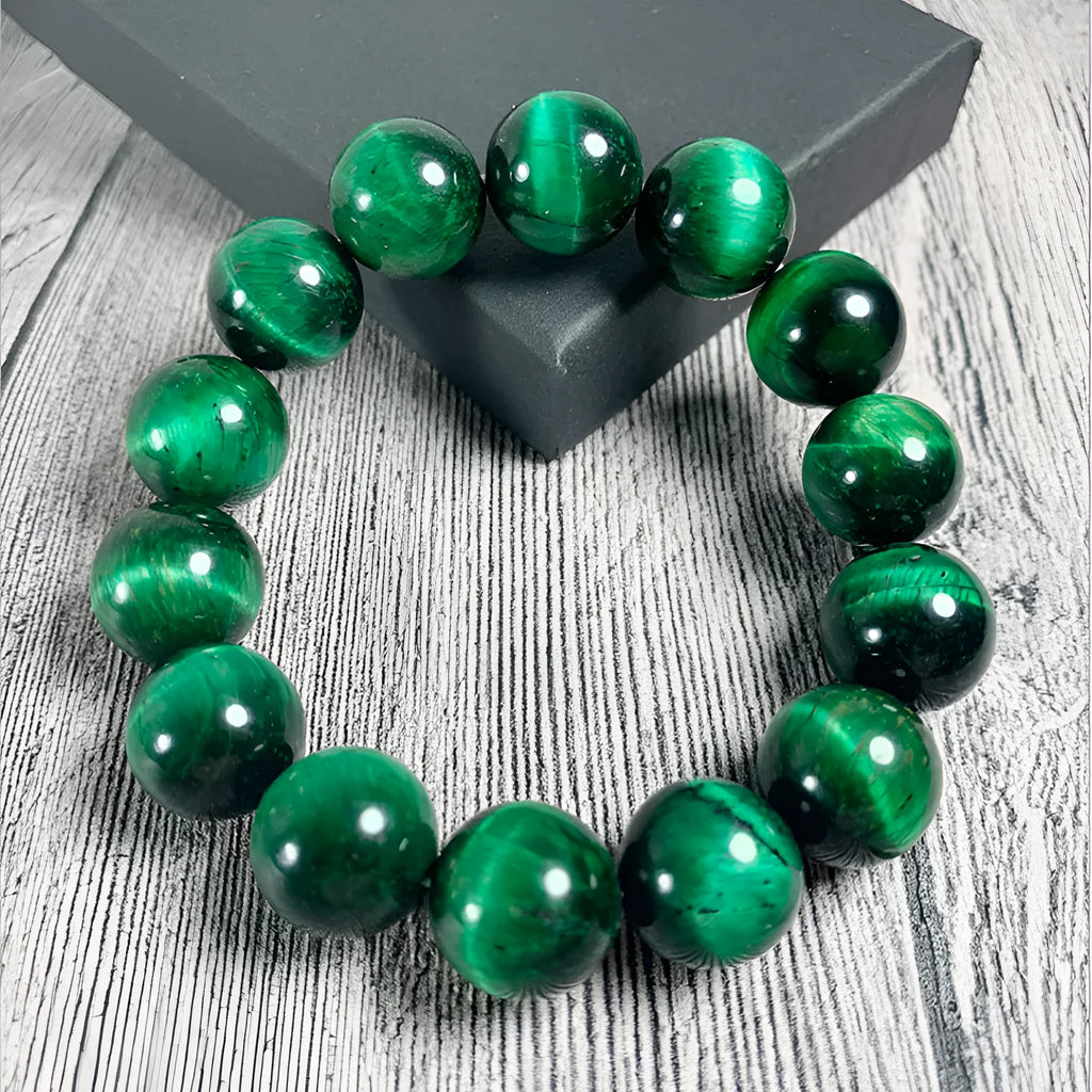 Natural green tiger eye stone bracelet with polished spherical beads in geometric design on wrist.