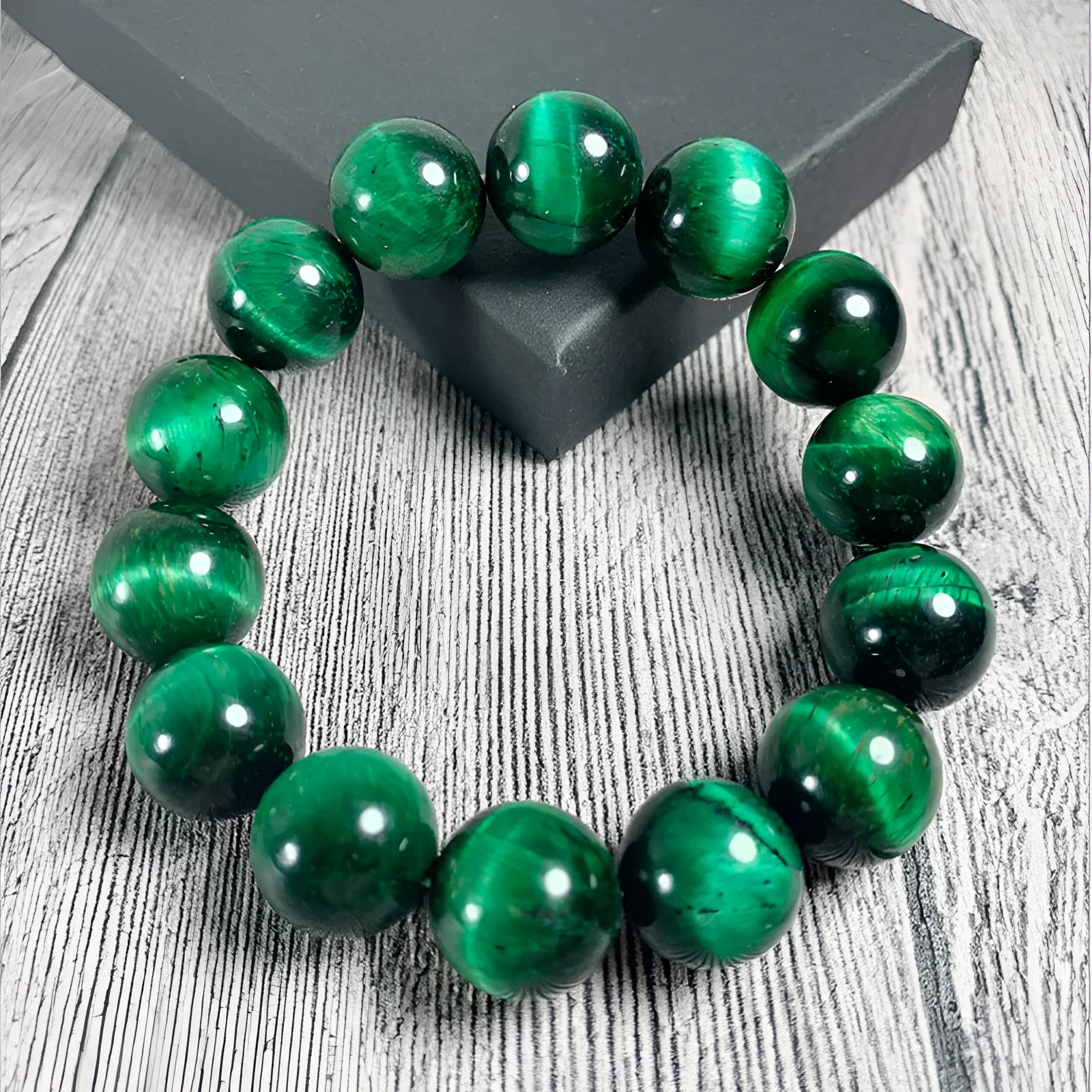 Natural green tiger eye stone bracelet with polished spherical beads in geometric design on wrist.