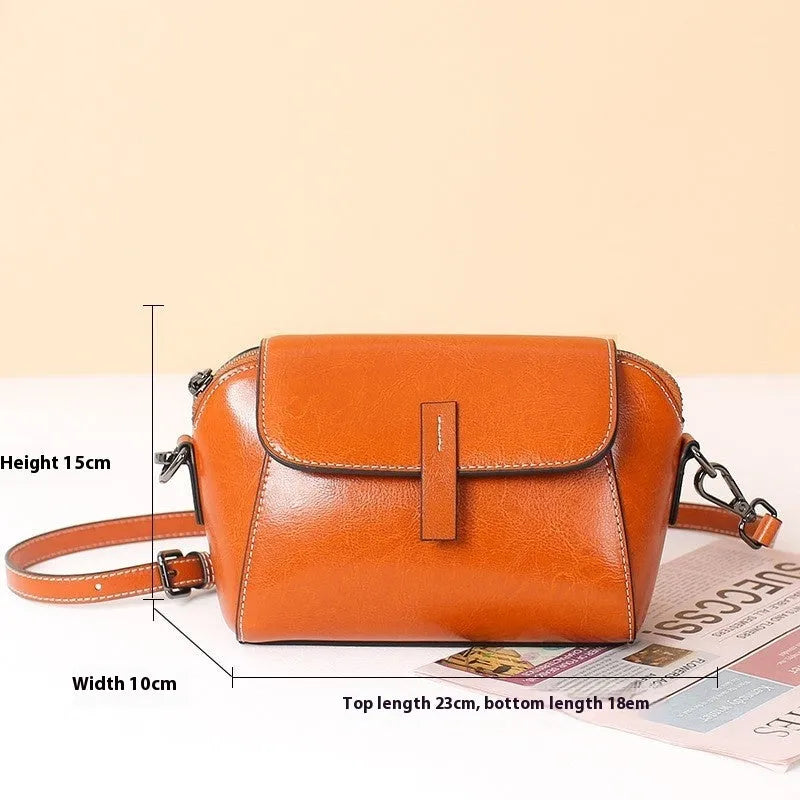 Women's brown oil-wax cowhide leather shell-shaped messenger bag with crossbody strap and visible sewing details