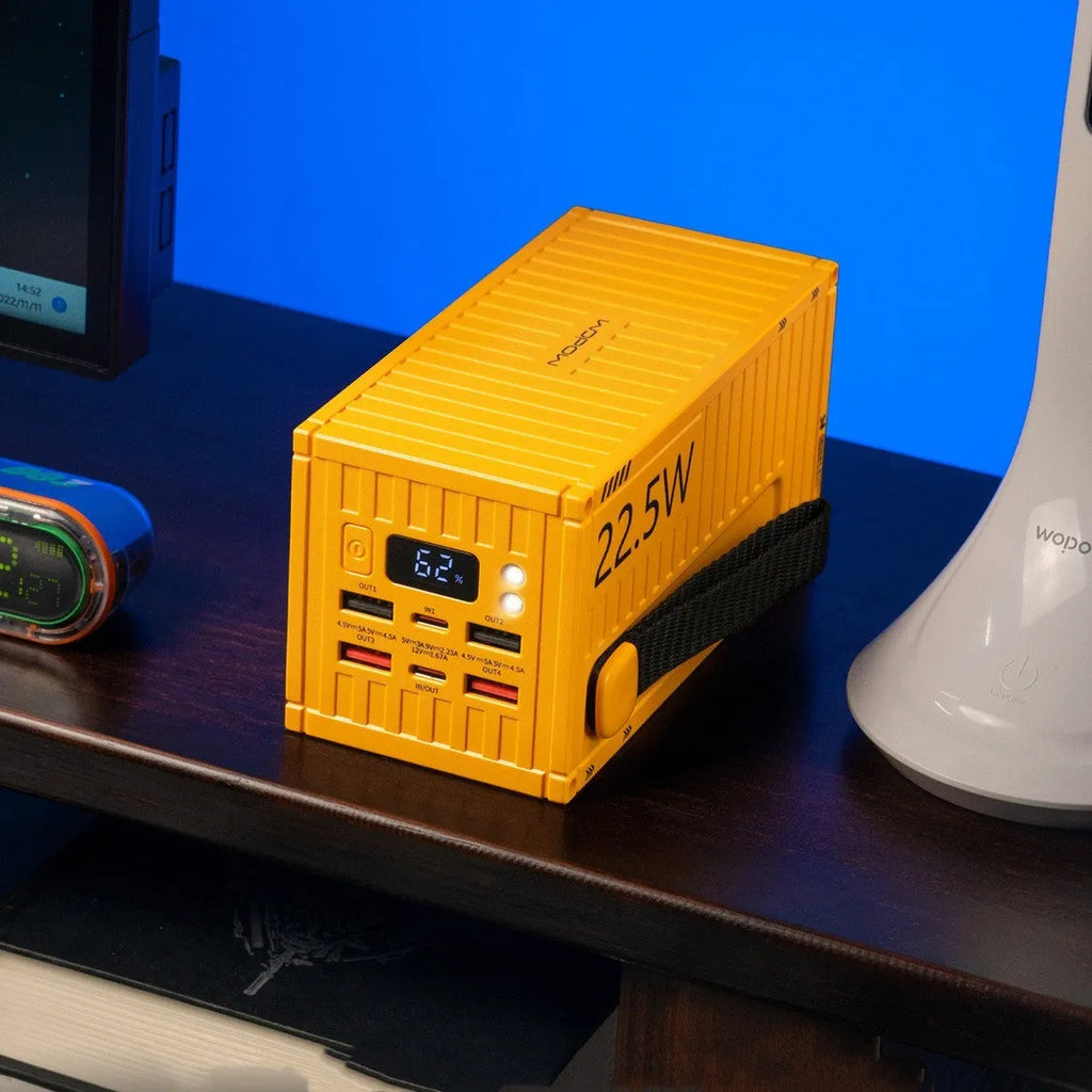 Yellow, black, and silver 50000mAh power bank with digital display screen and multiple USB ports.