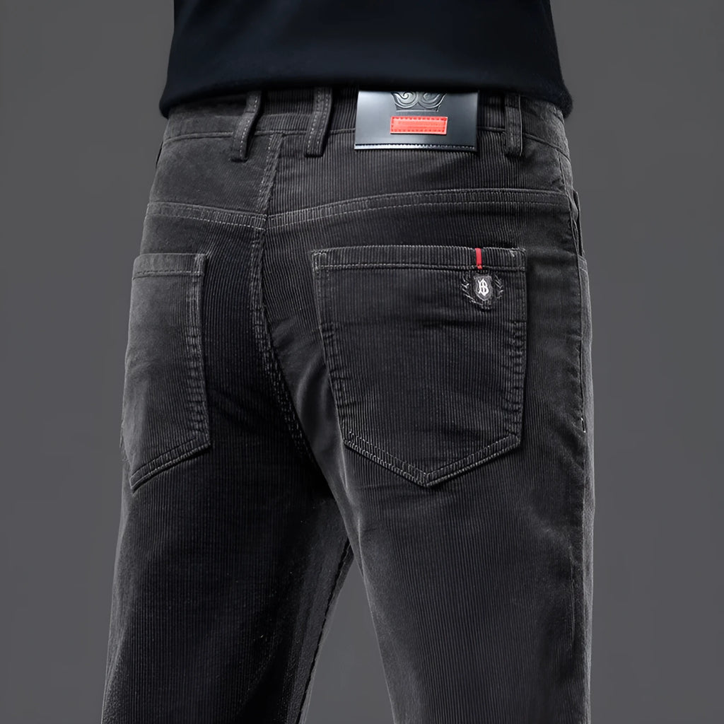 Men's thick corduroy straight trousers with belt in dark grey, shown folded on a neutral background.