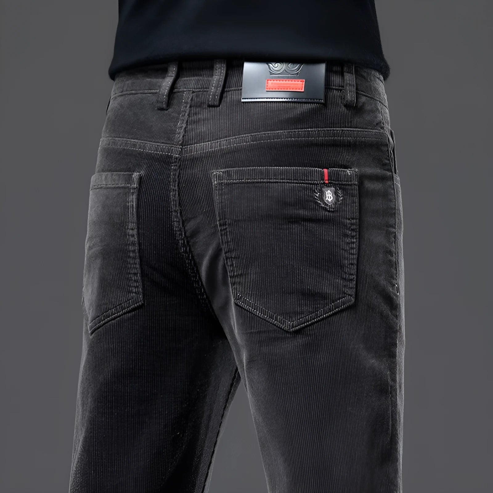 Men's thick corduroy straight trousers with belt in dark grey, shown folded on a neutral background.