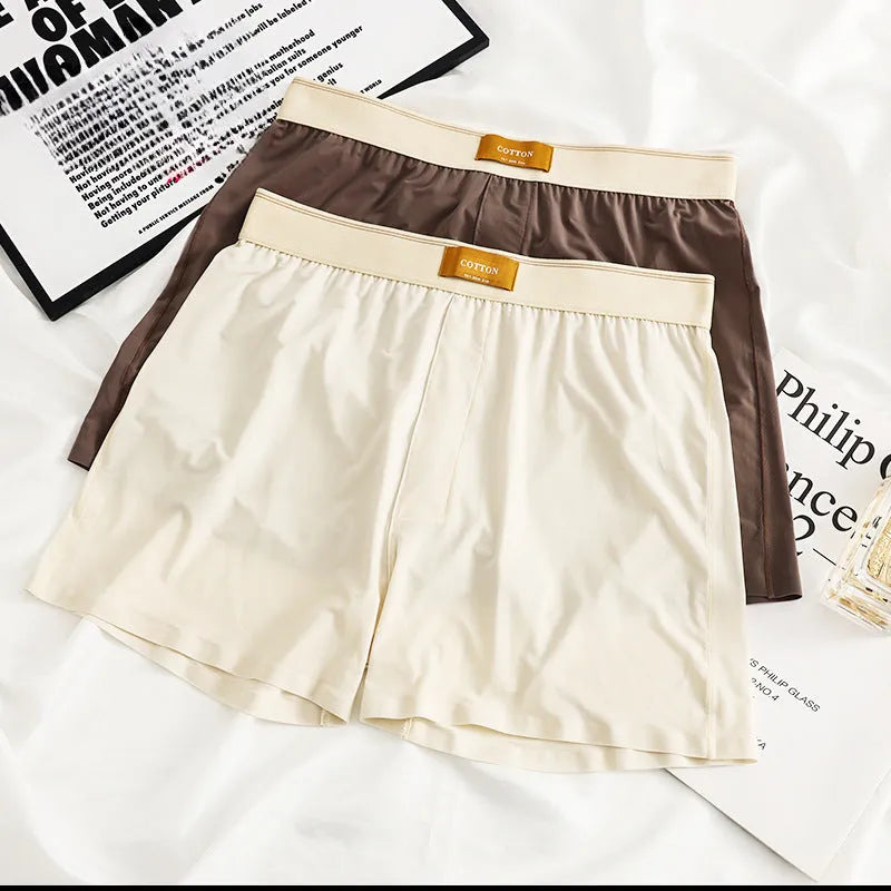 Pack of three men's solid colour loose fit ice silk boxer shorts on a white background