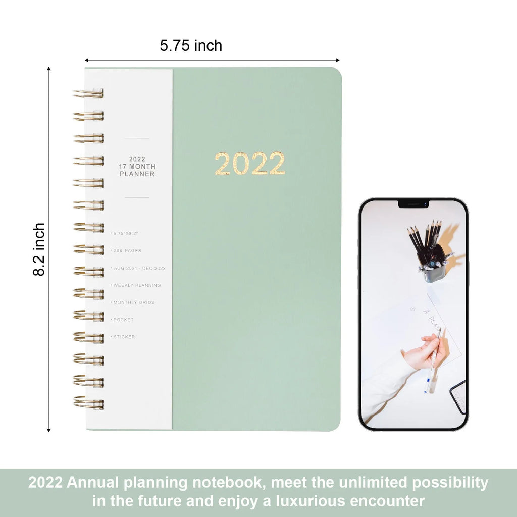 Green 2022 student weekly planner with coil binding, PU leather cover, open to show monthly grid and pockets.