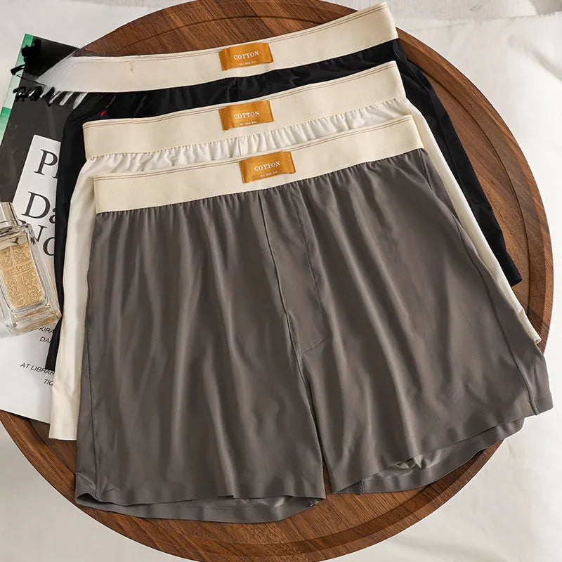 Pack of three men's solid colour loose fit ice silk boxer shorts on a white background