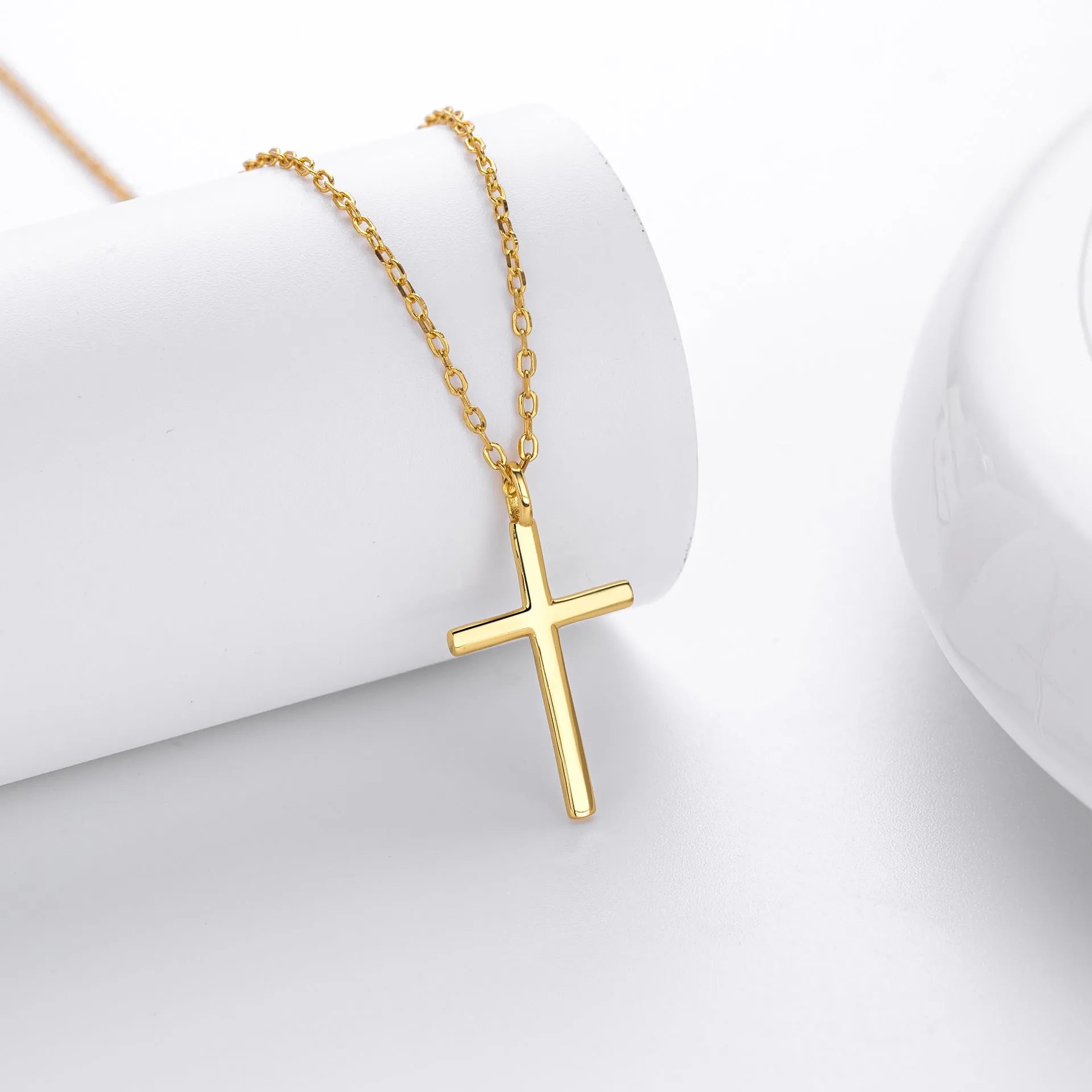 Sterling silver necklace with cross pendant on O-shaped chain showing gold electroplated finish