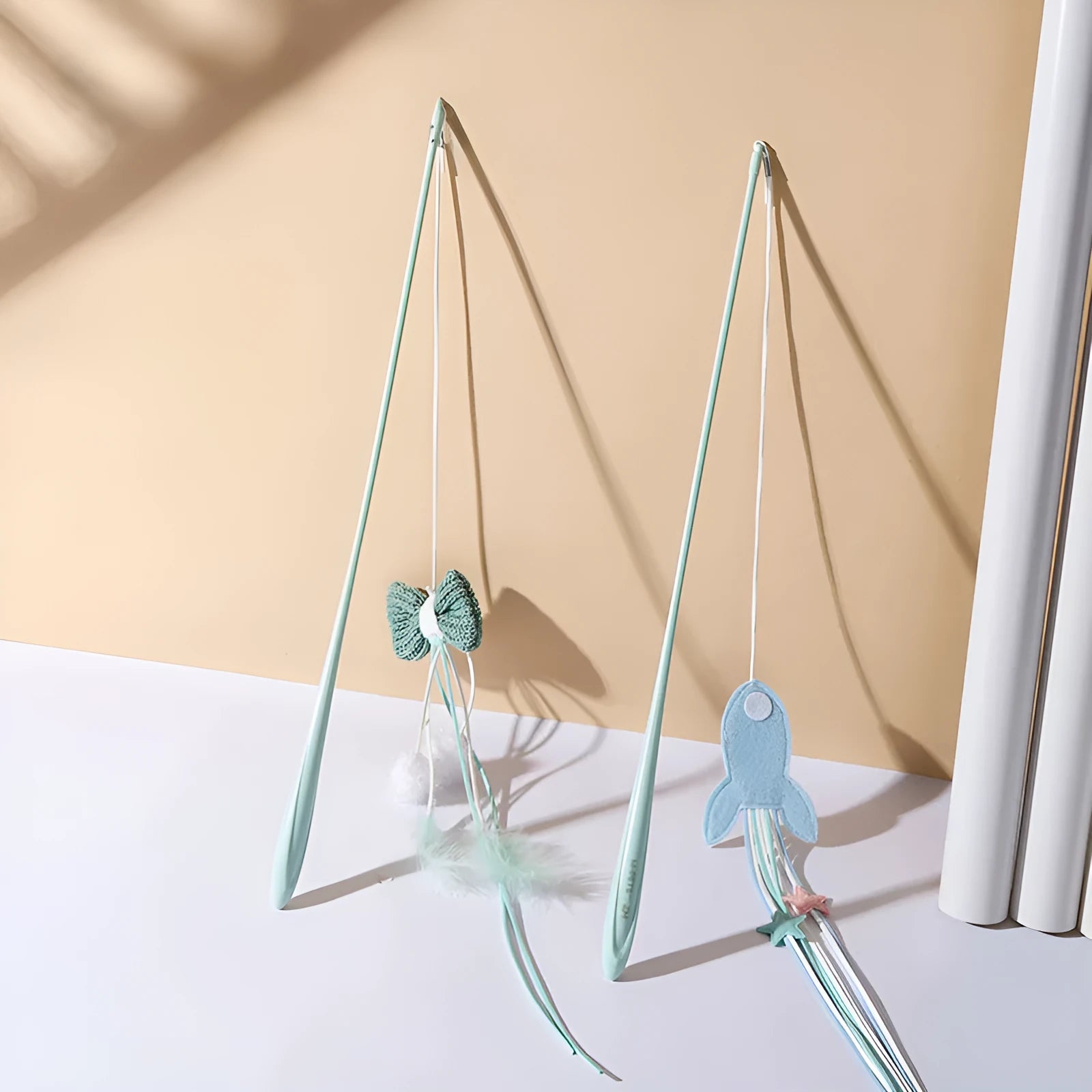Blue cat toy wand with long pole and a bite-resistant rocket attachment decorated with feathers.