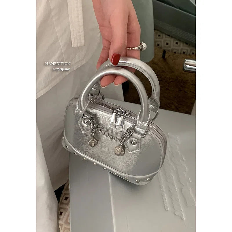 Champagne-gold PU shell bag with stitched seams, worn as a shoulder bag against a neutral background