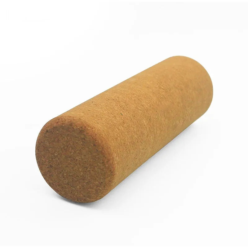 Natural cork yoga wand cylinder 30x10cm massage roller on a yoga mat with green background
