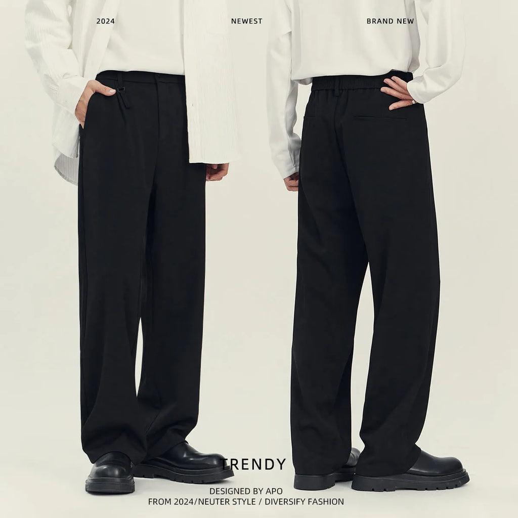 Man wearing loose straight-leg black business casual trousers made from polyester blend fabric.
