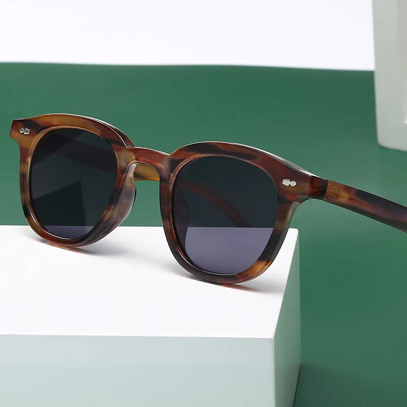 Round retro sunglasses with a metal hinge, shown in black frame with gradient tea lens option.