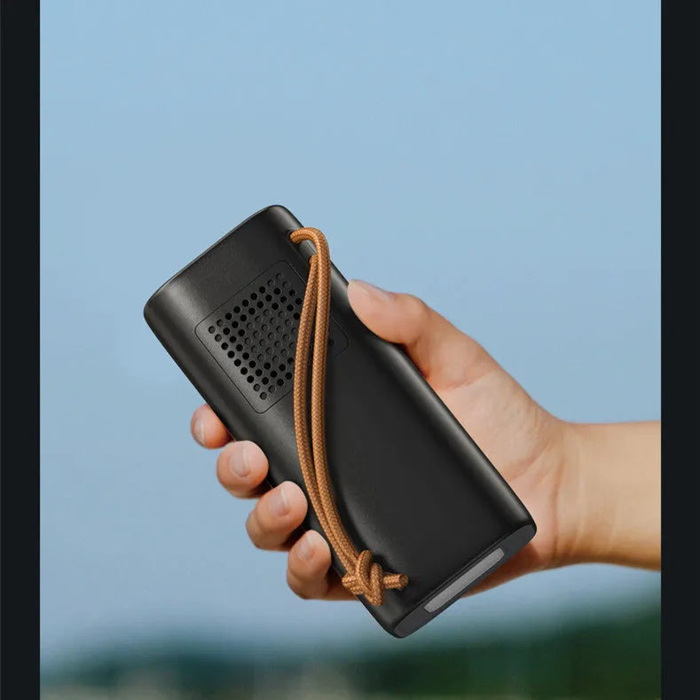 Black portable power bank with digital display, showing solar panel and car charging cables.