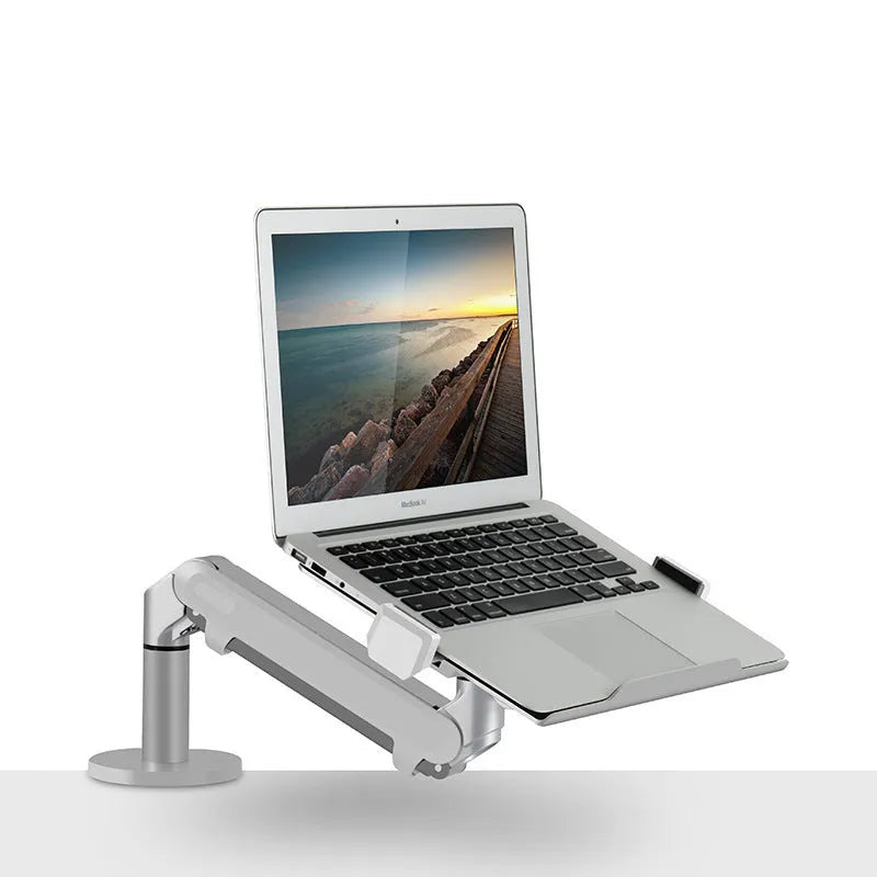 Silver aluminium Free Hover adjustable laptop and monitor arm bracket extended on a desk.
