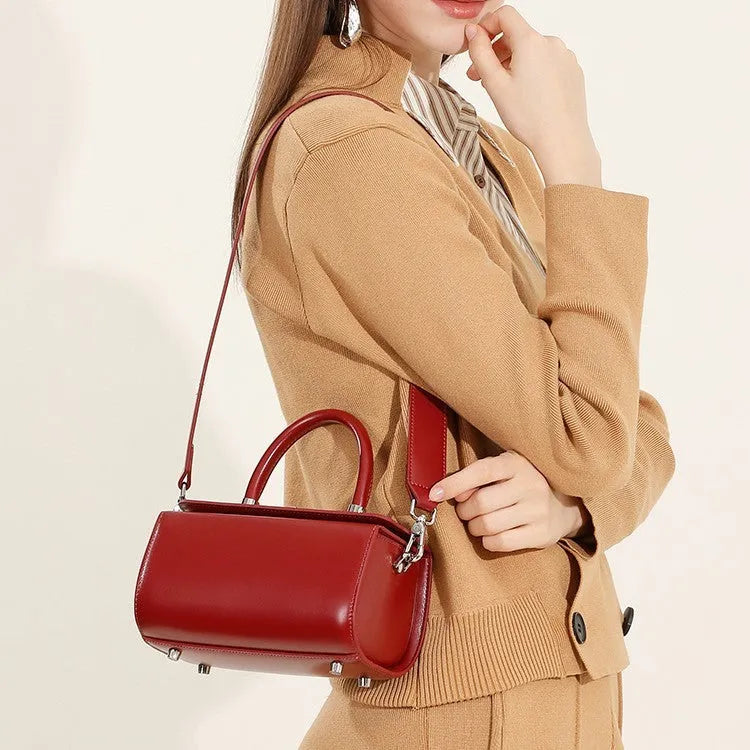 Structured leather women's crossbody bag in a clamshell design, shown in one of four colour options.