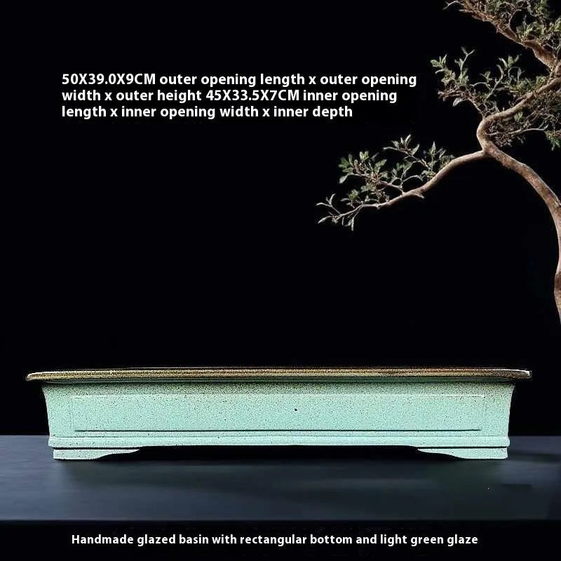 Green handmade ceramic bonsai pot with retro crackled glaze finish on wooden surface