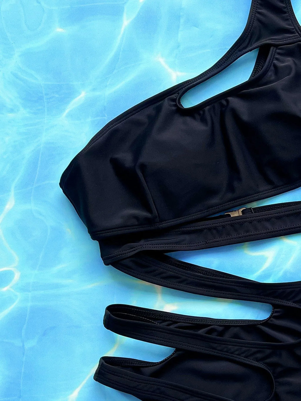Black women's one-piece swimsuit with hollow-out strap detail on a mannequin.