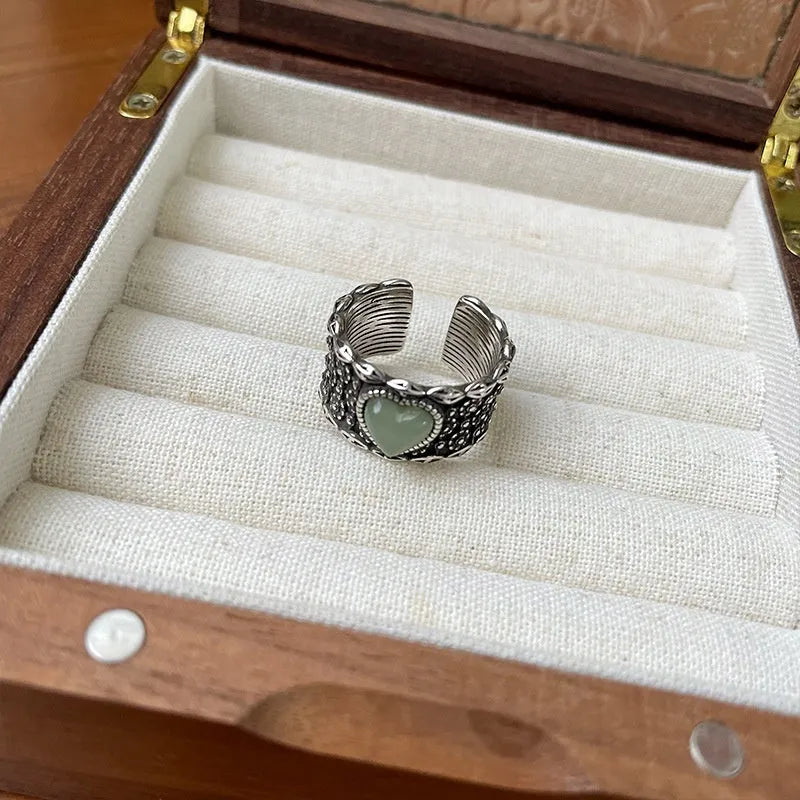Retro wide-faced silver heart ring with adjustable opening on a white background.