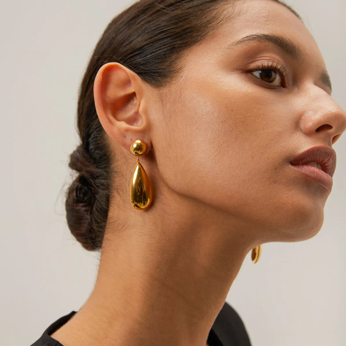 Gold coloured stainless steel earrings with a geometric shape and water drop pendant.