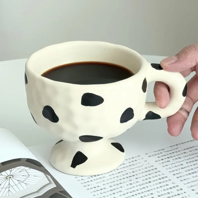 Hand-pinched irregular shaped ceramic mug in a solid colour, showing its unique handmade form.