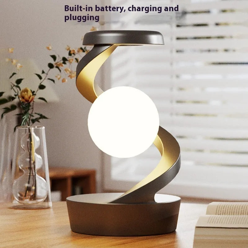 Rotating moon desk lamp with wireless charger in grey on a bedside table