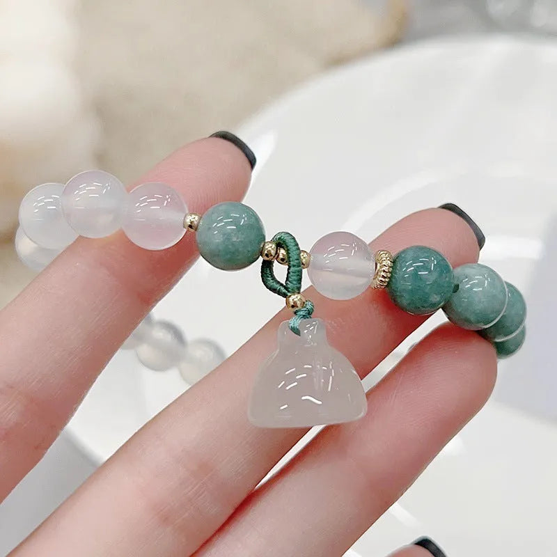Close-up of a women's retro Chinese style agate bracelet with a lotus seedpod design.