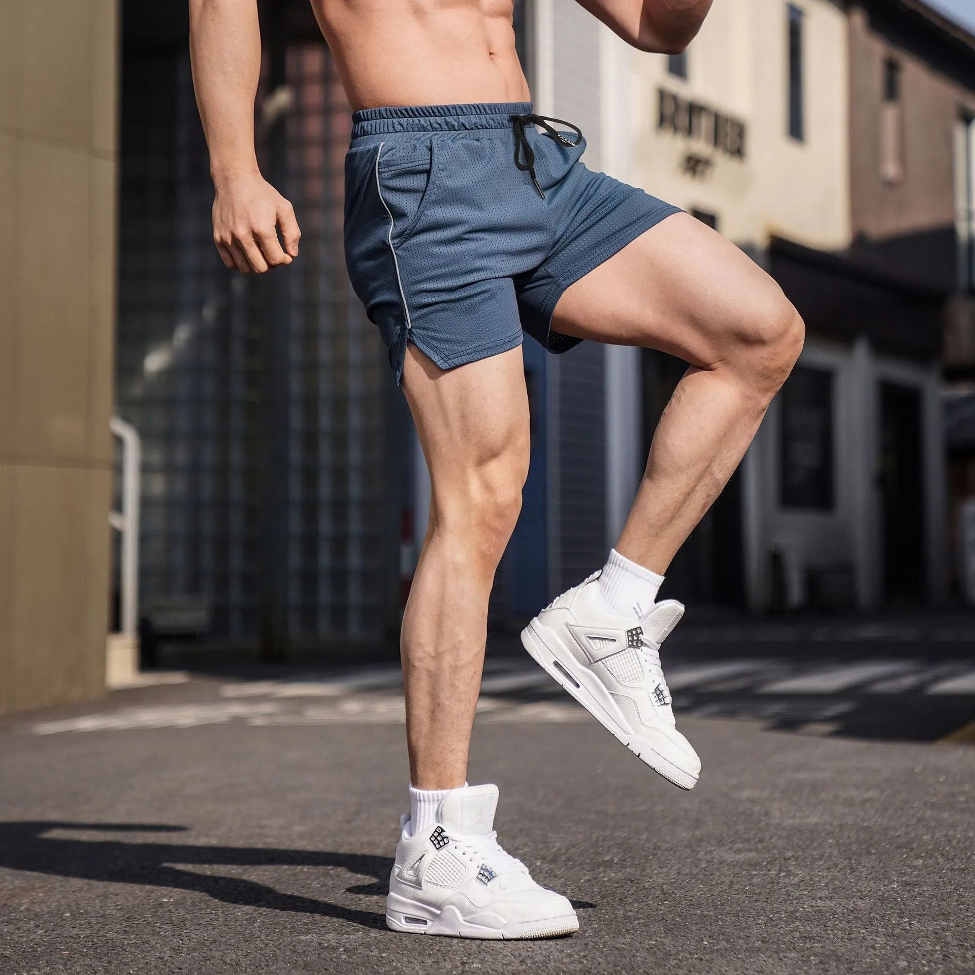 Men's black polyester straight-cut fitness shorts on a size chart
