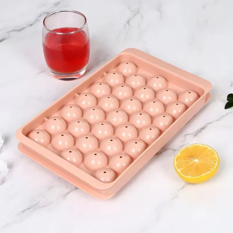 Silicone ice cube tray with lid in blue or pink, showing 33 round ice moulds measuring 24x14 cm.