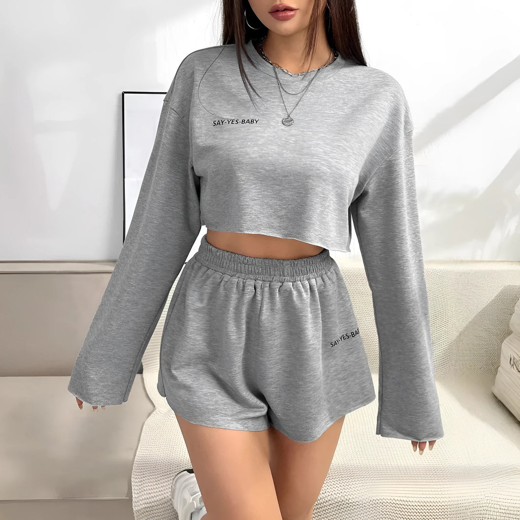 Grey women's polyester tracksuit set with long sleeve t-shirt and matching shorts laid flat.