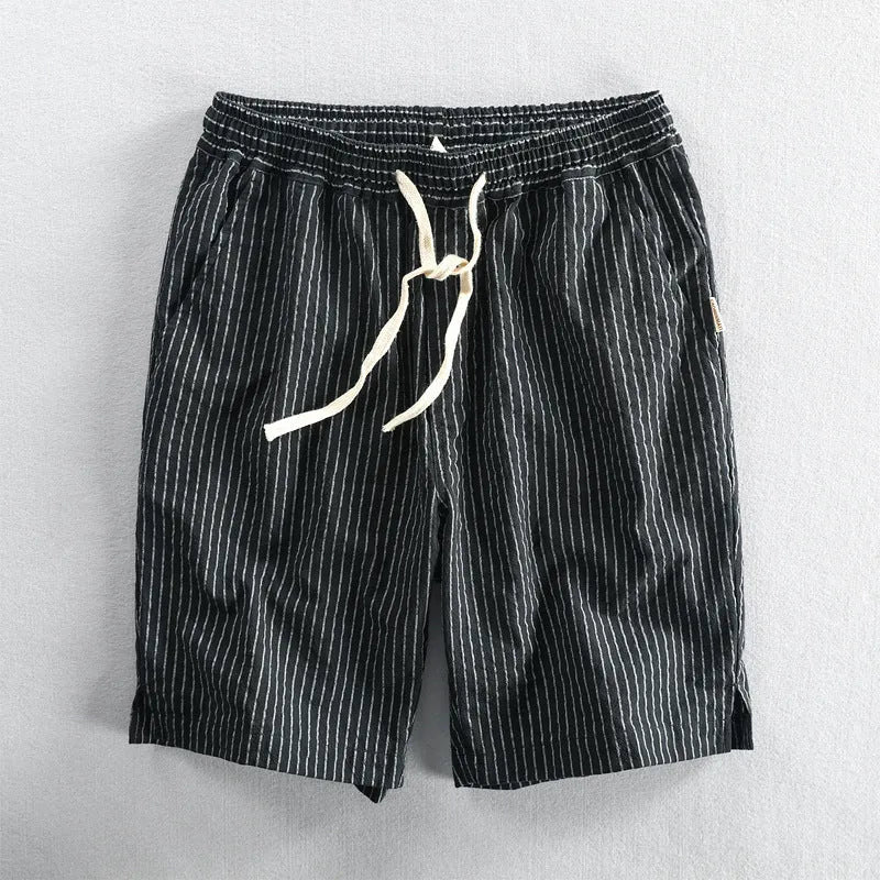 Man wearing black and white striped cotton casual shorts with a loose straight fit.