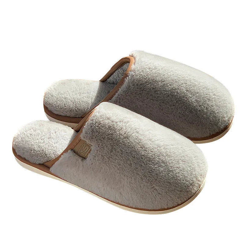 Pair of solid-colour plush winter slippers with a PVC upper and non-slip sole.