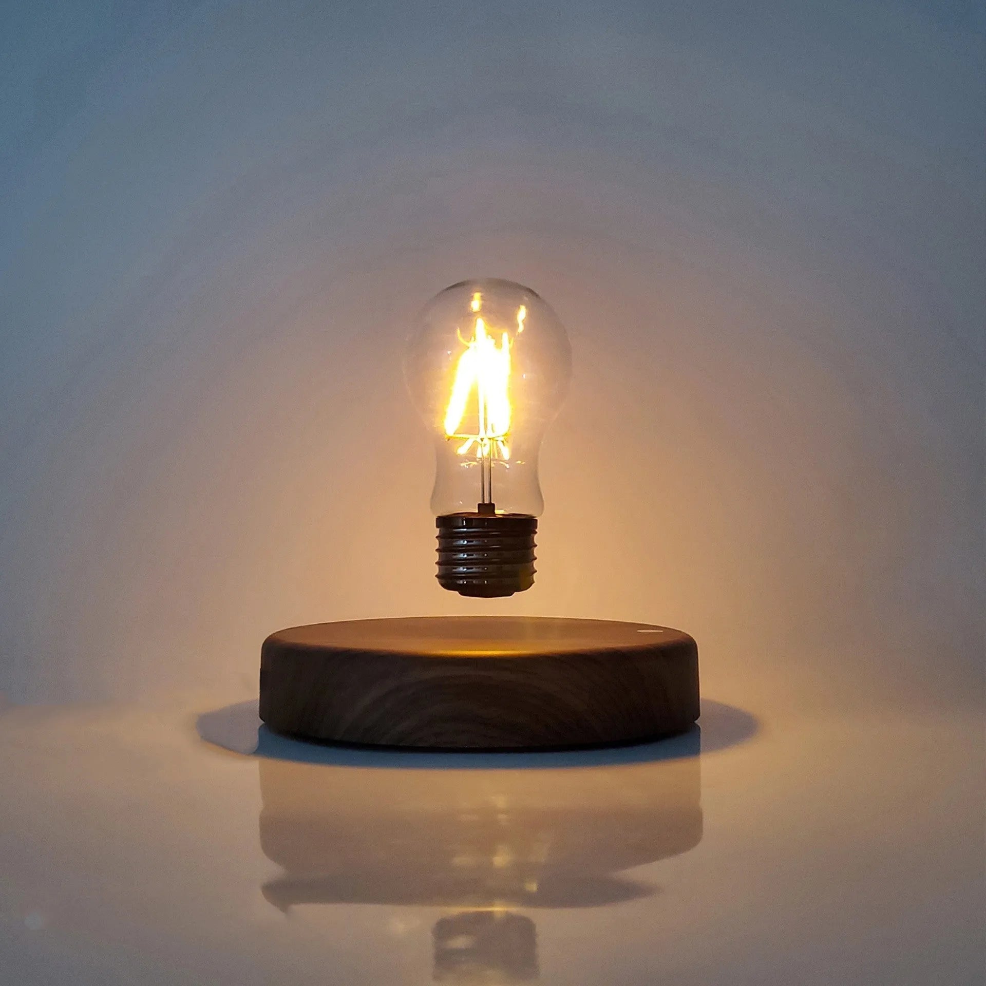 Magnetic levitation bulb night light in solid wood colour floating above plastic base
