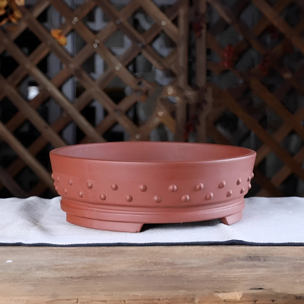 Chinese style indoor tabletop drum nail purple clay ceramic flowerpot with breathable design in purple clay colour on a wooden surface