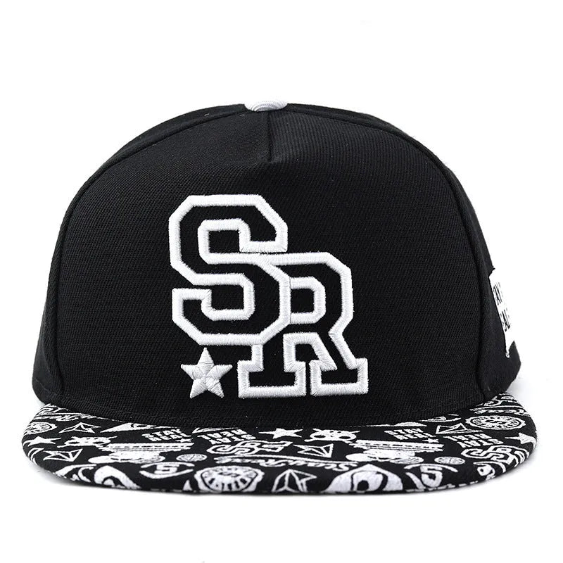 Cotton baseball cap with adjustable strap in black or white, showing embroidered letter detail on the front.
