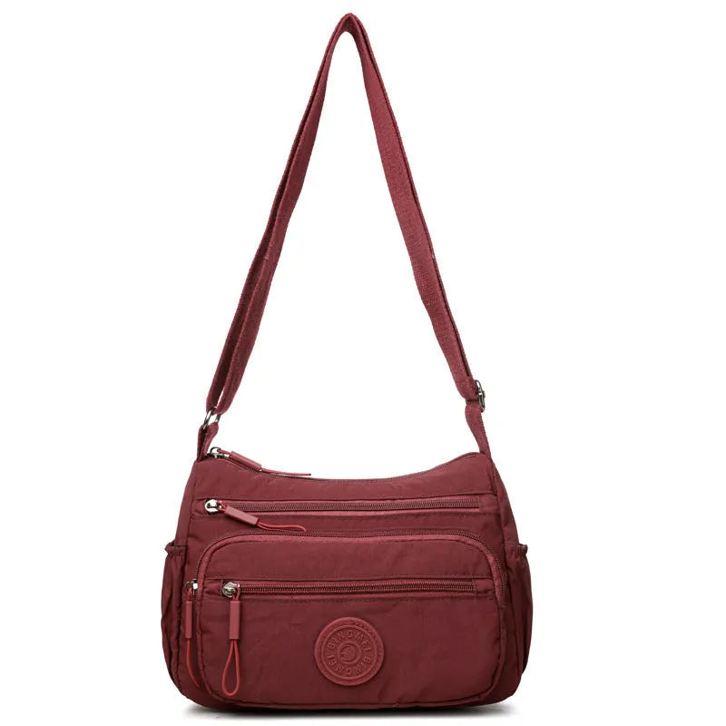 Water-repellent nylon crossbody cloth bag in black, grey or red with internal zipper compartments