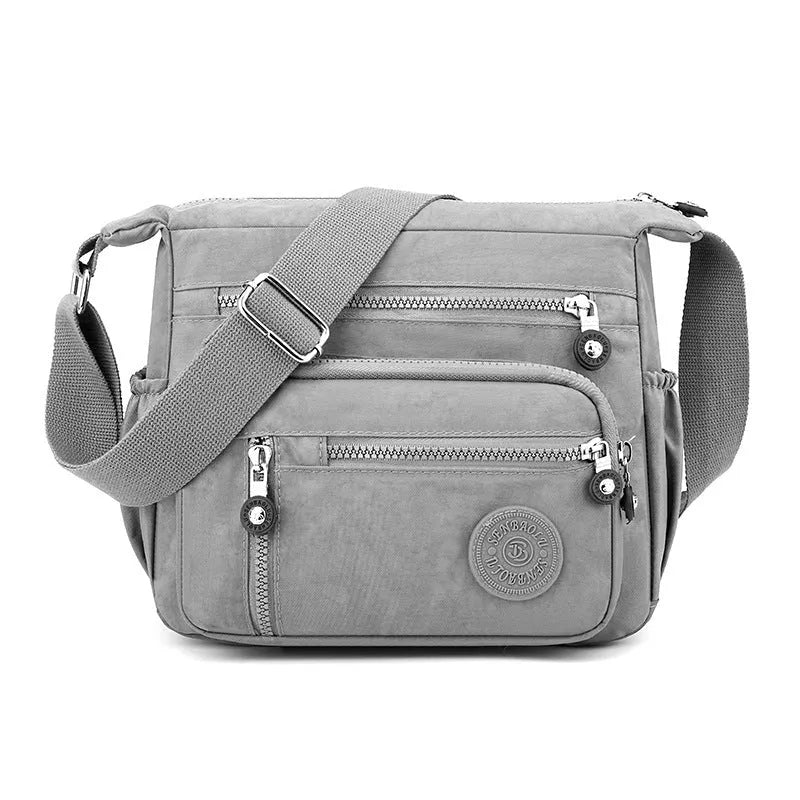 Soft grey nylon messenger bag with single shoulder strap showing square vertical shape