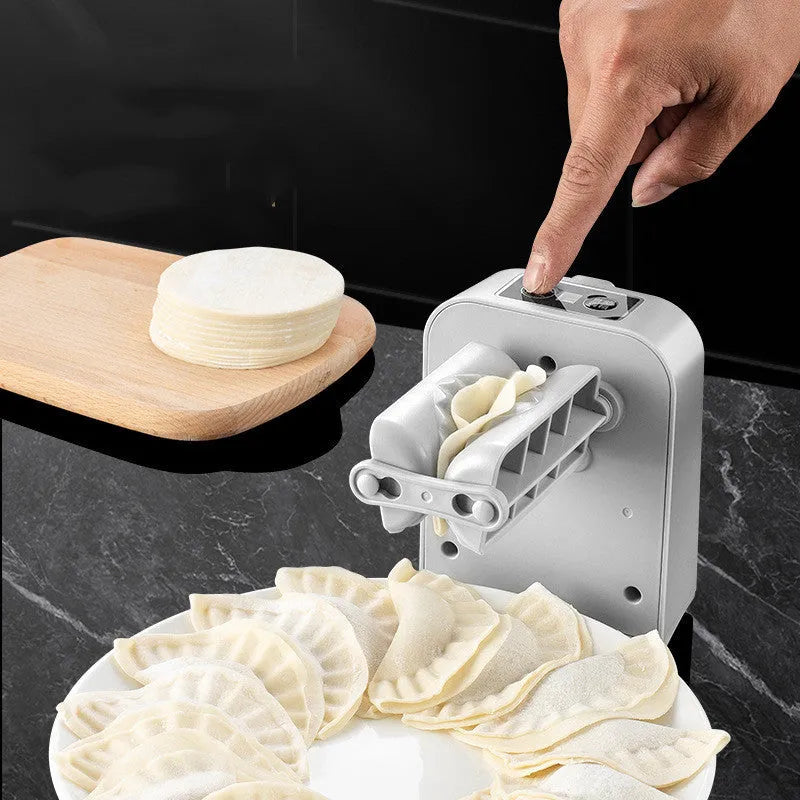 White electric automatic dumpling maker machine with accessories on a kitchen counter.