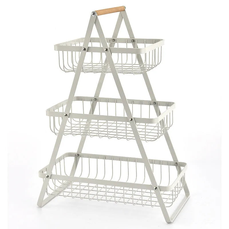 Black detachable iron double-layer fruit basket with a wooden handle on a kitchen counter.