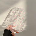 Transparent TPU phone case with crushed flower flowing sand pattern for Apple iPhone showing camera cutout and 3D keys