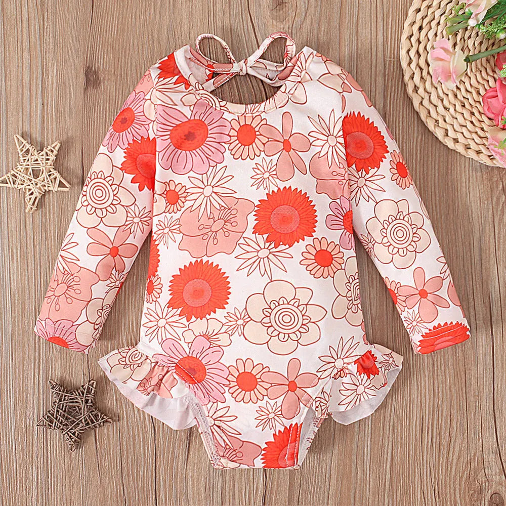 Girl's floral print open back swimsuit in orange red, shown from front and back.